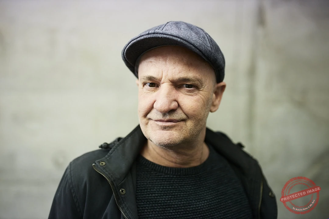 Markus Schnabel Mann trägt grauen Hut und schwarze Jacke, Blick in die Kamera.